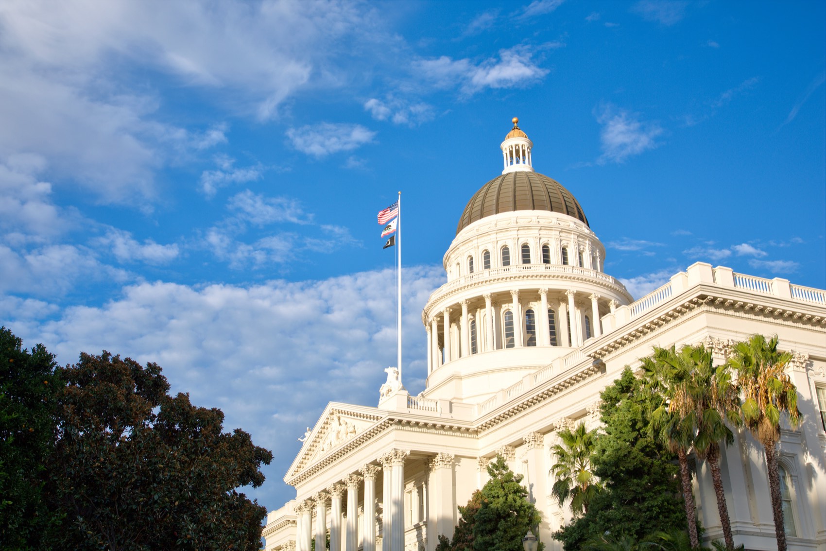 The California State Capitol dome in Sacramento against a blue sky.